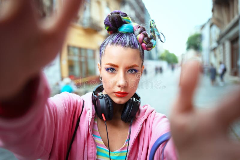 La jeune fille géniale fraîche avec des écouteurs et les cheveux fous apprécient la puissance de la musique prenant le selfie sur photos stock La jeune fille géniale fraîche avec des écouteurs et les cheveux fous apprécient la puissance de la musique prenant le selfie sur photos stock