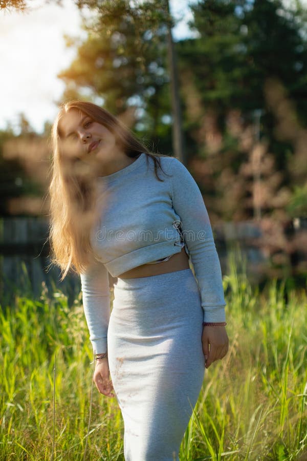 La jeune fille heureuse se tient en parc d'été images libres de droits La jeune fille heureuse se tient en parc d'été images libres de droits