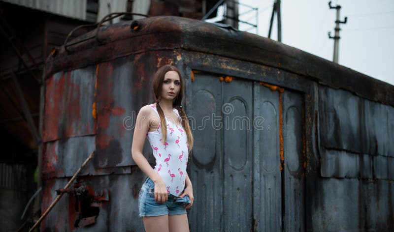 La jeune fille sexy se déshabille sur un fond de la réunion dans le style de la courrier-apocalypse image libre de droits La jeune fille sexy se déshabille sur un fond de la réunion dans le style de la courrier-apocalypse image libre de droits