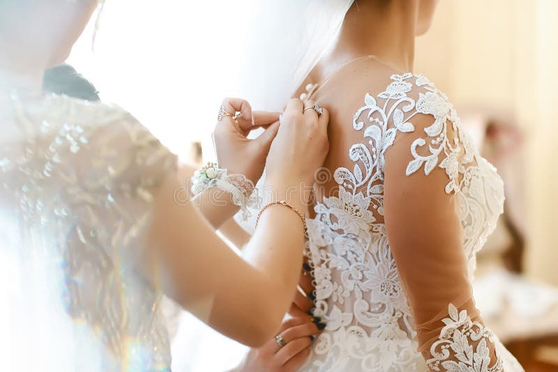 La jeune mariée magnifique et blonde dans la robe de luxe blanche est prête pour épouser Préparations de matin Femme mettant sur images stock La jeune mariée magnifique et blonde dans la robe de luxe blanche est prête pour épouser Préparations de matin Femme mettant sur images stock