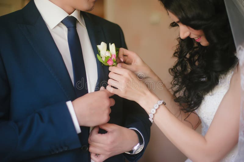 La jeune mariée orne le marié de costume de mariage de boutonnière, mariage, célébration, fleurs, marié, jeune mariée, mode de vi image stock La jeune mariée orne le marié de costume de mariage de boutonnière, mariage, célébration, fleurs, marié, jeune mariée, mode de vi image stock