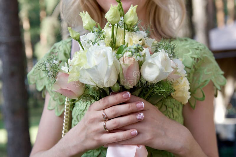 La jeune mariée tient dans des ses mains un bouque l'épousant images libres de droits La jeune mariée tient dans des ses mains un bouque l'épousant images libres de droits