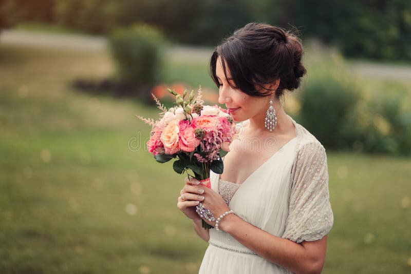 La jeune mariée tient le bouquet de mariage de boho images stock La jeune mariée tient le bouquet de mariage de boho images stock