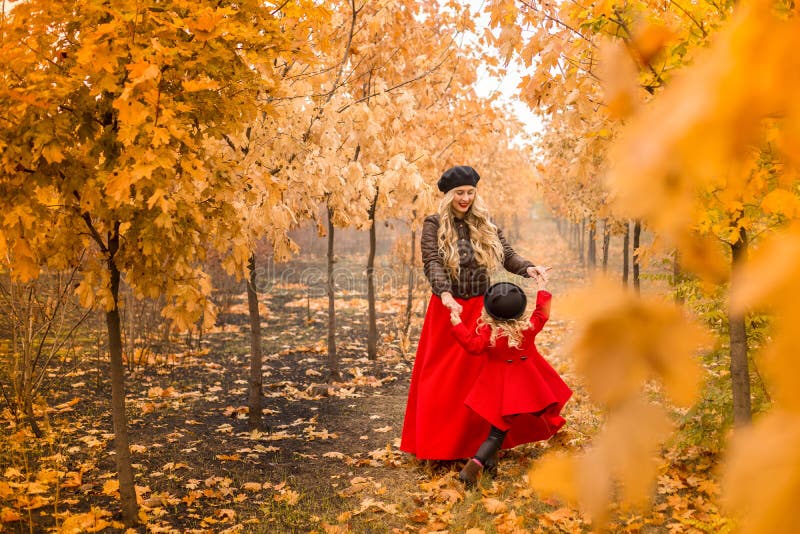 La jeune mère joue avec sa petite fille dans le jardin d'automne photo libre de droits La jeune mère joue avec sa petite fille dans le jardin d'automne photo libre de droits