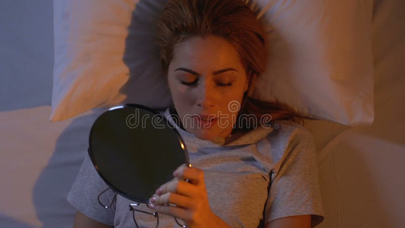 La jolie élimination de femme composent de son visage, se préparant au sommeil, des astuces de beauté banque de vidéos