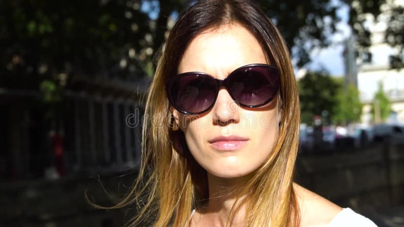 La joven del retrato con gafas de sol considera que las actitudes de la cámara metrajes