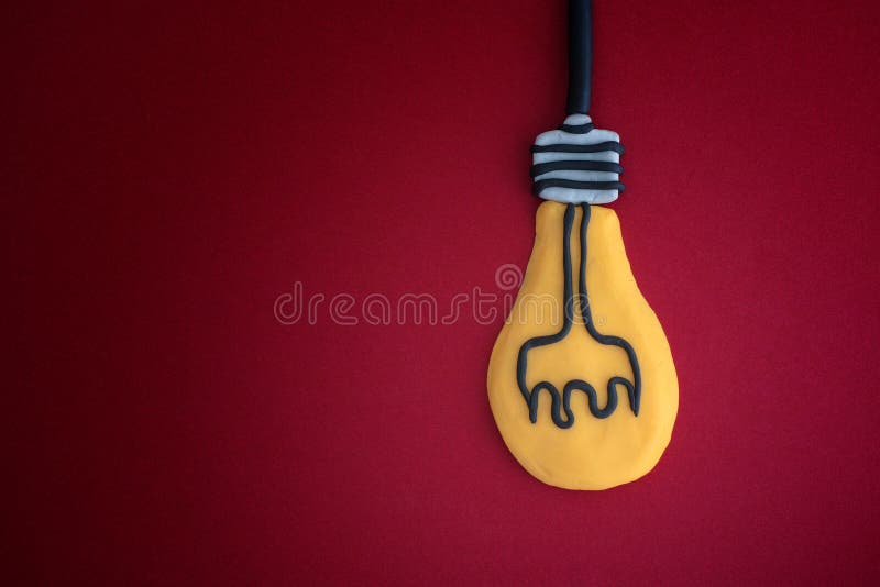 La lampadina ha fatto fuorigioco l'argilla su fondo rosso Concetto di idea fotografia stock La lampadina ha fatto fuorigioco l'argilla su fondo rosso Concetto di idea fotografia stock