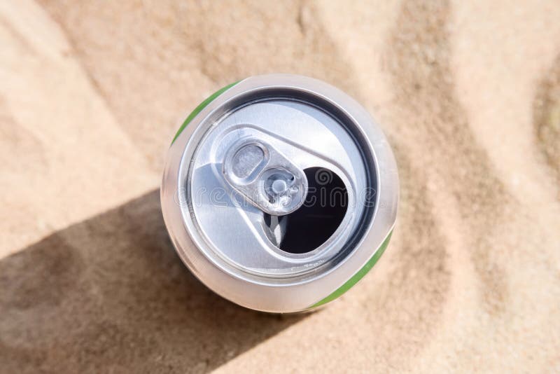La latta di alluminio della birra sta sulla sabbia della spiaggia fotografia stock La latta di alluminio della birra sta sulla sabbia della spiaggia fotografia stock