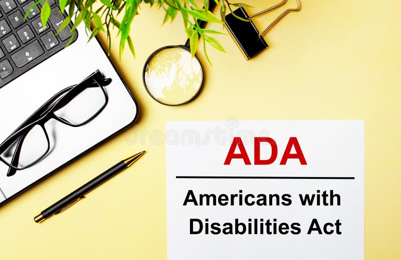 La legge americana sulle disabilità è scritta in rosso su un foglio bianco su uno sfondo giallo chiaro accanto a una penna portati