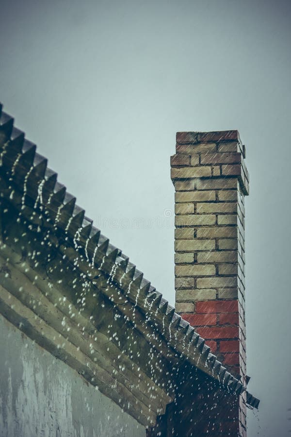La lluvia fluye abajo de un tejado abajo fotos de archivo La lluvia fluye abajo de un tejado abajo fotos de archivo