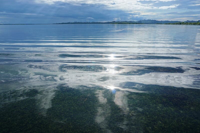 La luce solare ha riflesso sull'acqua calma con il cielo nuvoloso fotografie stock La luce solare ha riflesso sull'acqua calma con il cielo nuvoloso fotografie stock