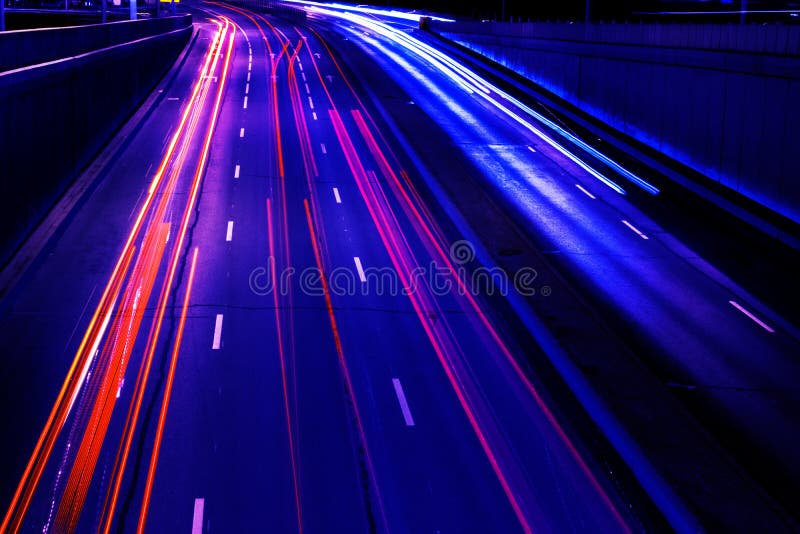 La lumi?re de voitures tra?ne sur une route incurv?e la nuit Tra?n?es du trafic de nuit Tache floue de mouvement Route urbaine de image libre de droits La lumi?re de voitures tra?ne sur une route incurv?e la nuit Tra?n?es du trafic de nuit Tache floue de mouvement Route urbaine de image libre de droits