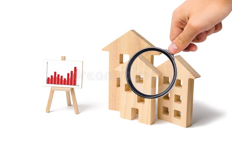 Magnifying glass is looking at the wooden houses with a stand of graphics and information. Growing demand for housing and real estate. Statistics on the state of the market. Investments. Magnifying glass is looking at the wooden houses with a stand of graphics and information. Growing demand for housing and real estate. Statistics on the state of the market. Investments
