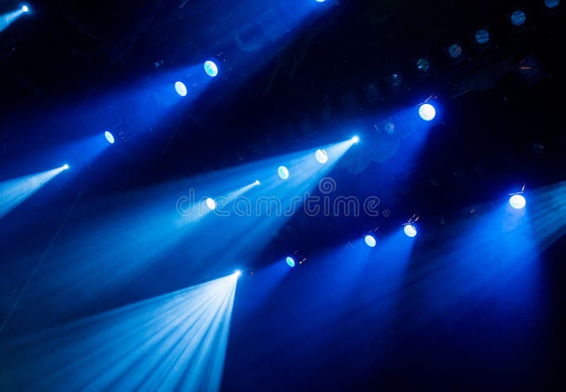 La luz azul de los proyectores a través del humo en el teatro durante el funcionamiento foto de archivo La luz azul de los proyectores a través del humo en el teatro durante el funcionamiento foto de archivo