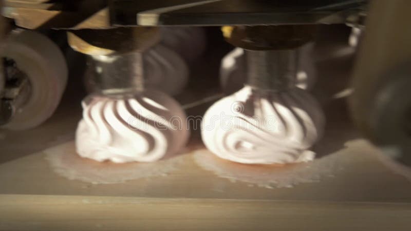 La macchina per la compressione dei marshmallow produce zephyrs rosa in una fabbrica di caramelle