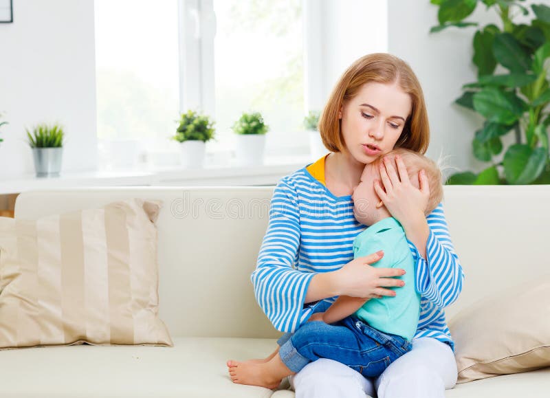 La madre calma al hijo gritador del bebé fotografía de archivo libre de regalías La madre calma al hijo gritador del bebé fotografía de archivo libre de regalías