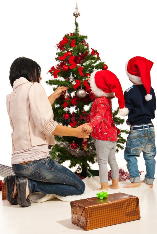 La madre con i bambini decora l'albero immagine stock libera da diritti