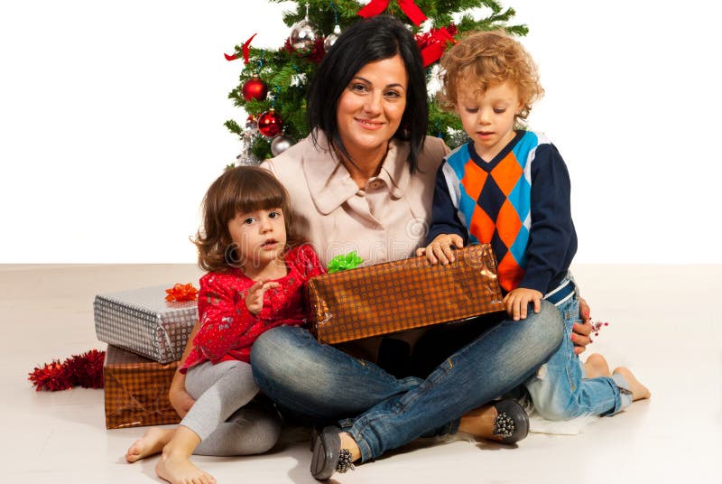 La madre con i bambini si avvicina all'albero di natale immagine stock