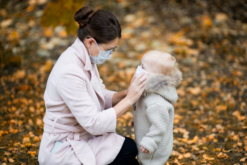 La Mamma Con Una Maschera in Viso Tiene in Braccio Una Bambina. Donna E  Bambino in Maschere Mediche Immagine Stock - Immagine di madre, infezione:  160787281