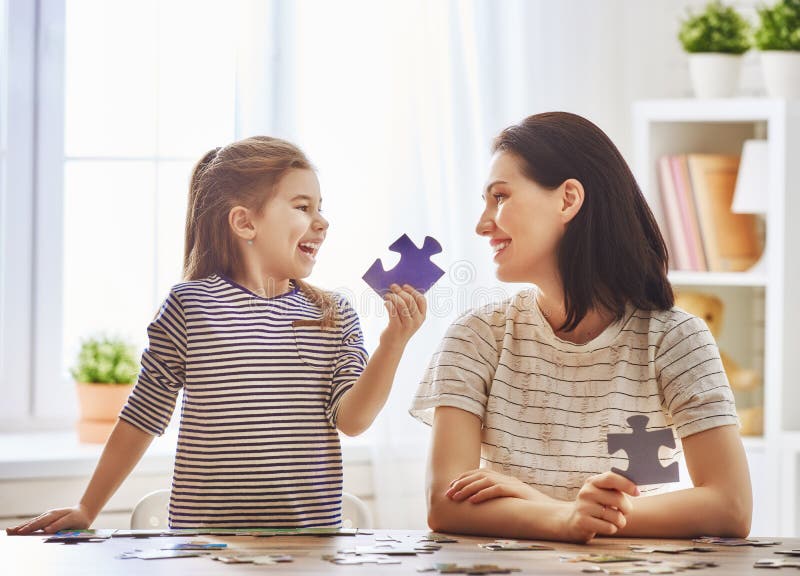 La madre e la figlia fanno i puzzle immagini stock libere da diritti La madre e la figlia fanno i puzzle immagini stock libere da diritti