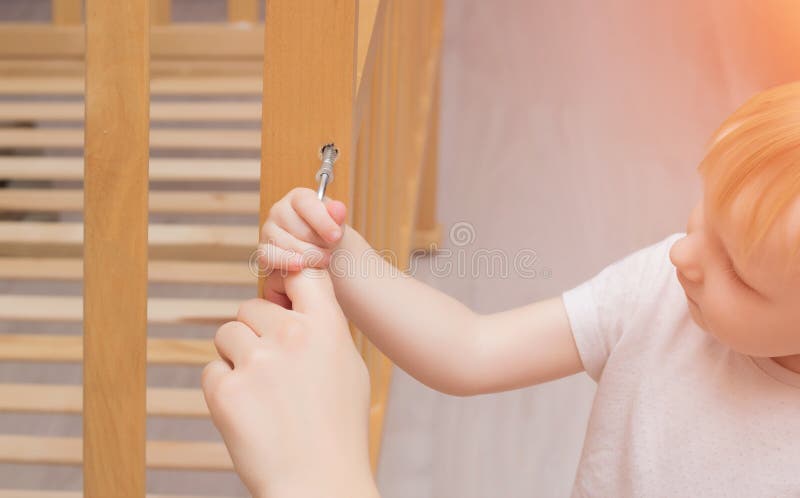 La madre ed il bambino stanno montando una greppia, primo piano, caucasico, greppia di legno dell'installazione fotografie stock libere da diritti La madre ed il bambino stanno montando una greppia, primo piano, caucasico, greppia di legno dell'installazione fotografie stock libere da diritti