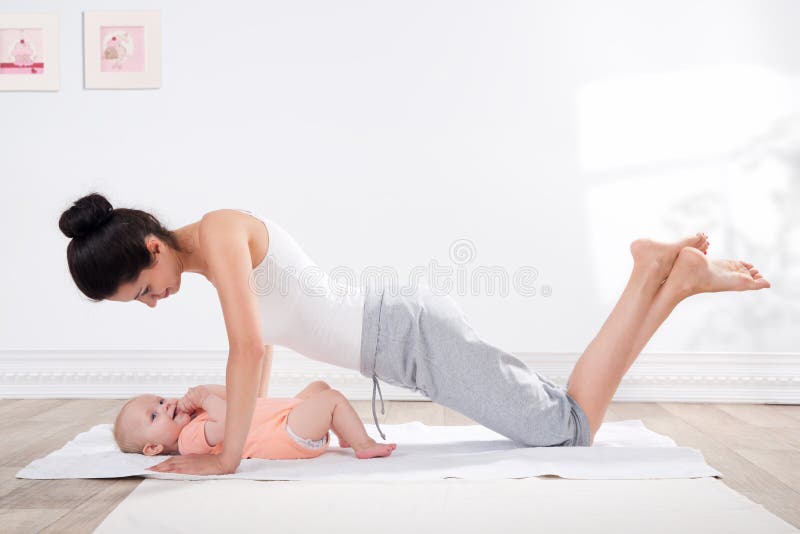 La madre fa la ginnastica con il suo bambino fotografia stock libera da diritti La madre fa la ginnastica con il suo bambino fotografia stock libera da diritti