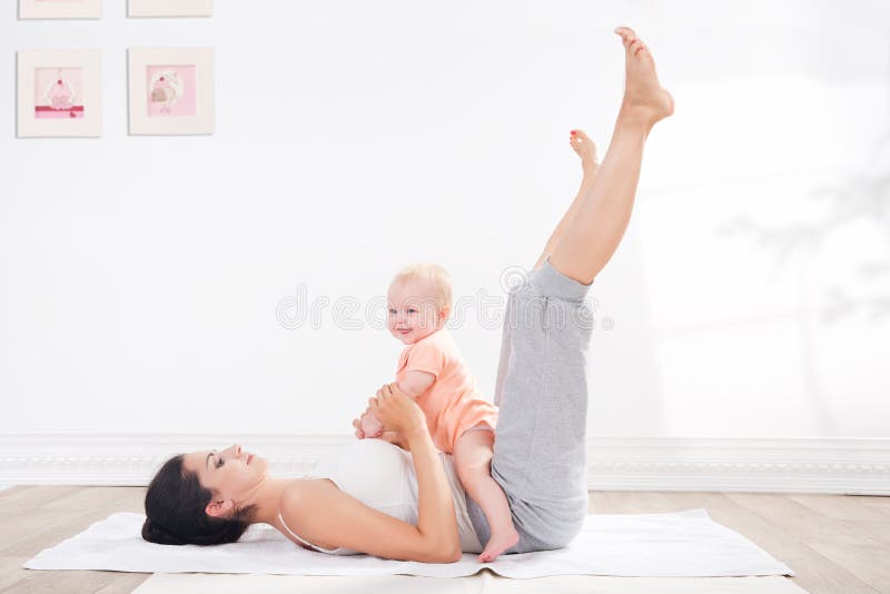 La madre hace la gimnasia con su bebé fotografía de archivo libre de regalías