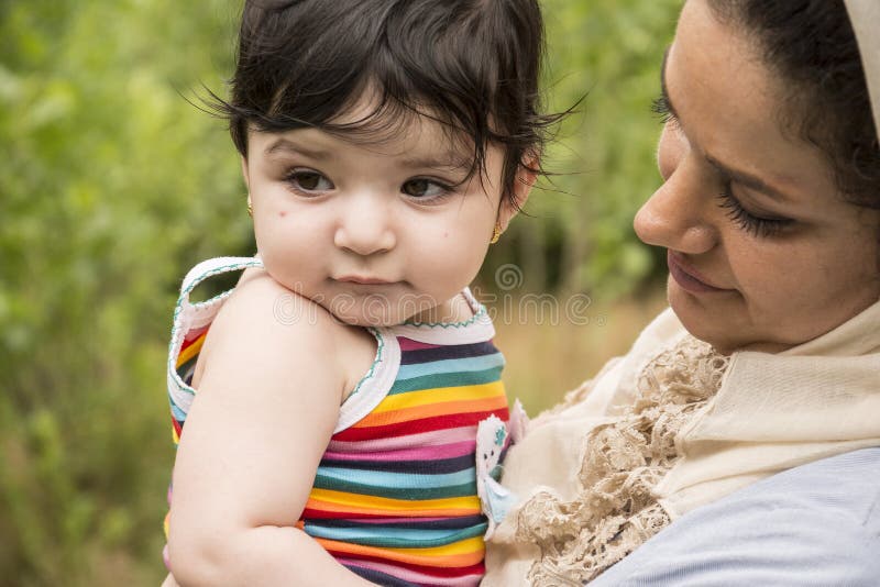 La madre musulmana ha abbracciato un piccolo bambino in enjo all'aperto di area della natura immagini stock libere da diritti La madre musulmana ha abbracciato un piccolo bambino in enjo all'aperto di area della natura immagini stock libere da diritti