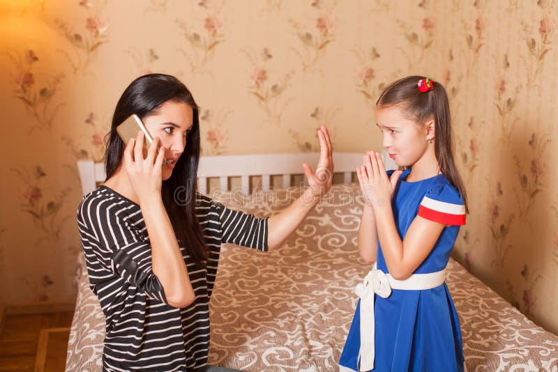 La madre pide que la hija mantenga silencioso imagenes de archivo La madre pide que la hija mantenga silencioso imagenes de archivo