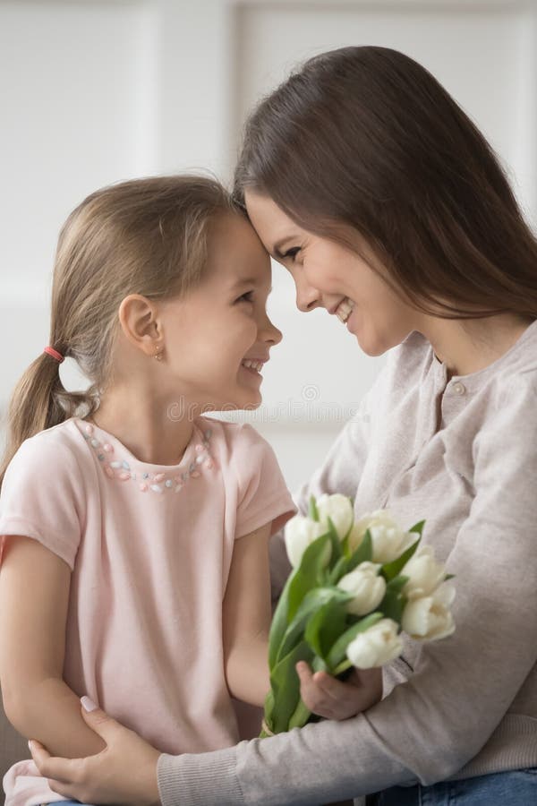 La madre riconoscente e la figlia che toccano delicatamente le fronti celebrano la festa della famiglia fotografie stock libere da diritti La madre riconoscente e la figlia che toccano delicatamente le fronti celebrano la festa della famiglia fotografie stock libere da diritti