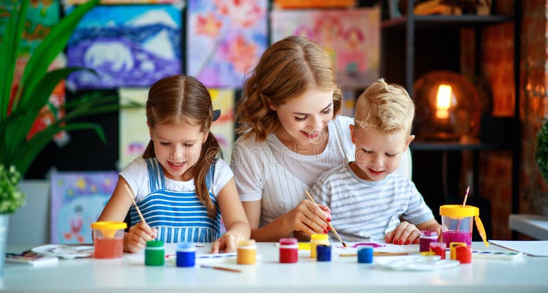 La madre y los niños hijo y la pintura de la hija dibuja en creatividad en guardería fotos de archivo La madre y los niños hijo y la pintura de la hija dibuja en creatividad en guardería fotos de archivo