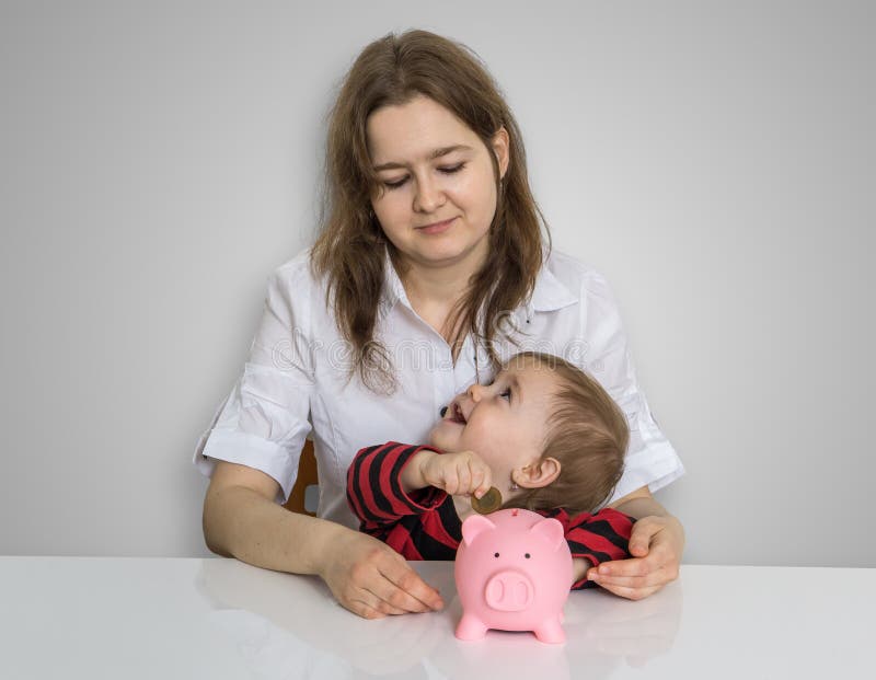 La madre y su niño están celebrando la hucha con ahorros fotos de archivo libres de regalías La madre y su niño están celebrando la hucha con ahorros fotos de archivo libres de regalías