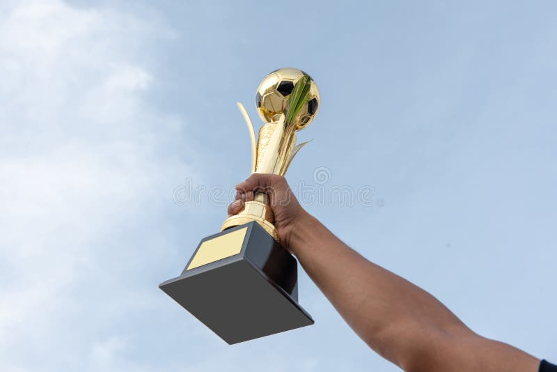 La main de l'athlète tient un trophée du football images libres de droits La main de l'athlète tient un trophée du football images libres de droits