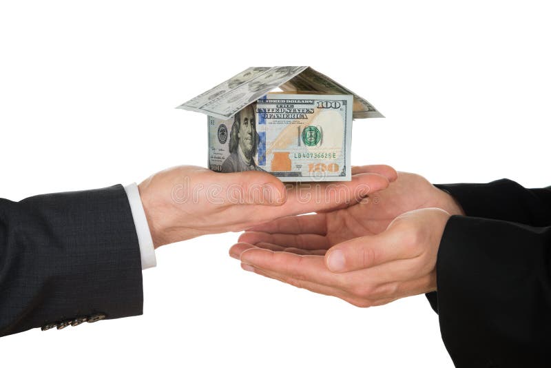 La main de l'homme d'affaires jugeant la maison faite en dollar américain images libres de droits La main de l'homme d'affaires jugeant la maison faite en dollar américain images libres de droits