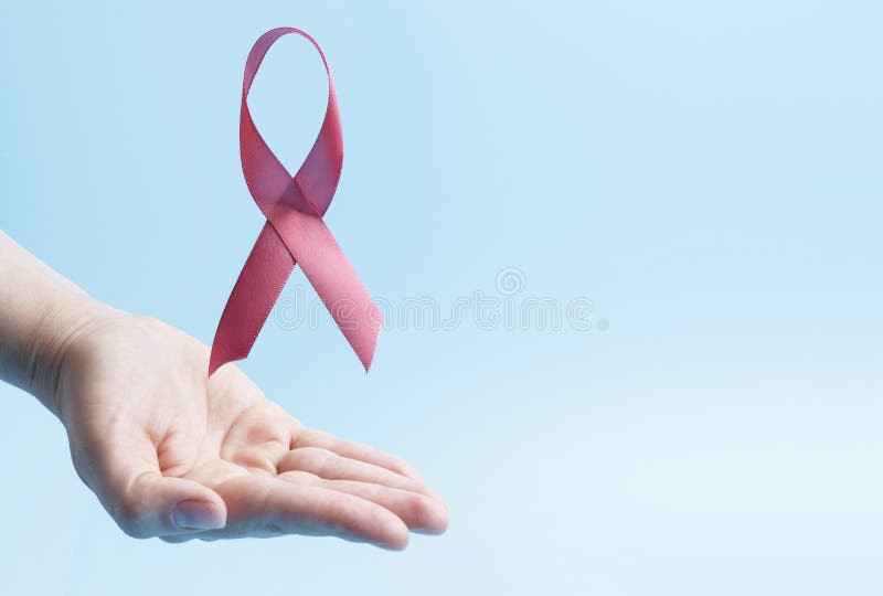 La main féminine tient du ruban rose sur fond bleu, concept de cancer du sein, espace de copie images libres de droits La main féminine tient du ruban rose sur fond bleu, concept de cancer du sein, espace de copie images libres de droits