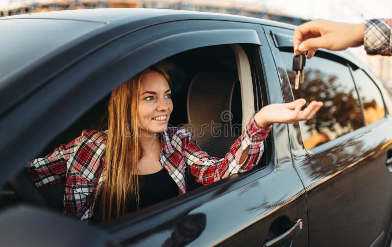 La main masculine donne les clés de voiture au conducteur femelle photographie stock La main masculine donne les clés de voiture au conducteur femelle photographie stock