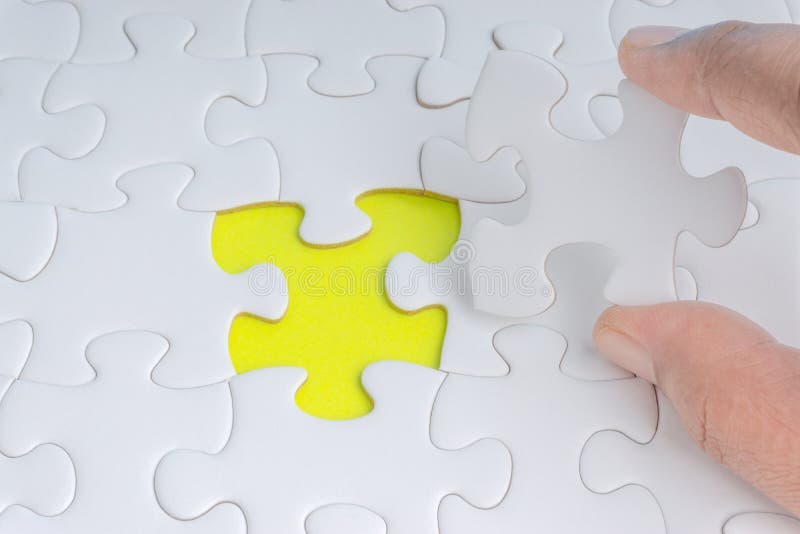 La main a mis le dernier morceau de plan rapproché de puzzle denteux pour accomplir la mission image stock La main a mis le dernier morceau de plan rapproché de puzzle denteux pour accomplir la mission image stock