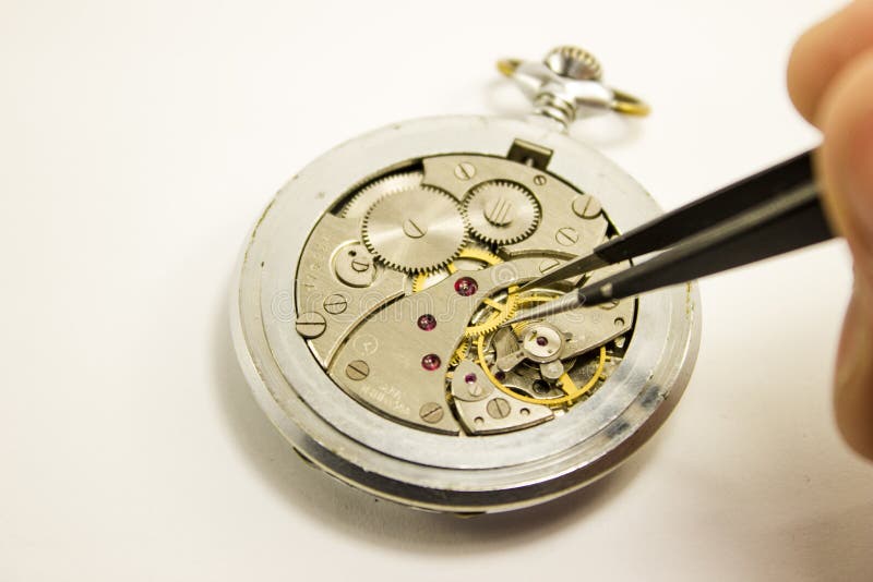 La main répare la montre mécanique sur le fond blanc photographie stock libre de droits La main répare la montre mécanique sur le fond blanc photographie stock libre de droits