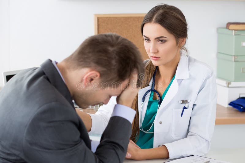 La main su du patient masculin de la participation du docteur féminin amical de médecine photo stock La main su du patient masculin de la participation du docteur féminin amical de médecine photo stock