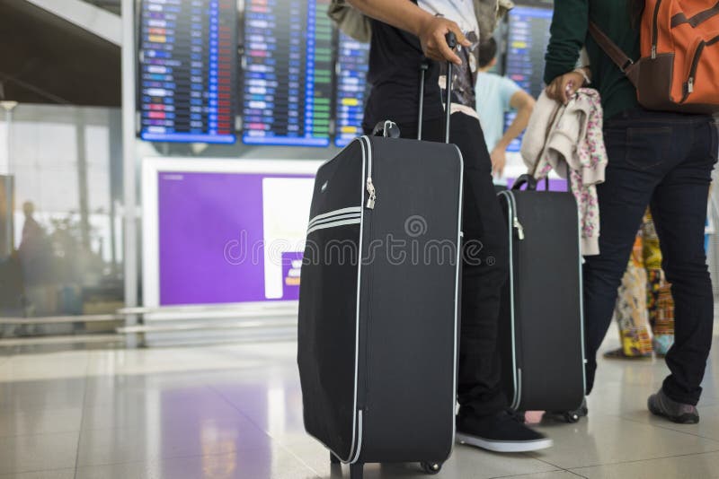 La maleta que viaja contra la información del vuelo sube en fondo Concepto de viaje en aeroplano foto de archivo La maleta que viaja contra la información del vuelo sube en fondo Concepto de viaje en aeroplano foto de archivo