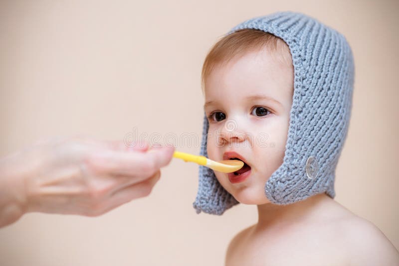 La maman alimente le bébé avec la purée de fruit images libres de droits La maman alimente le bébé avec la purée de fruit images libres de droits