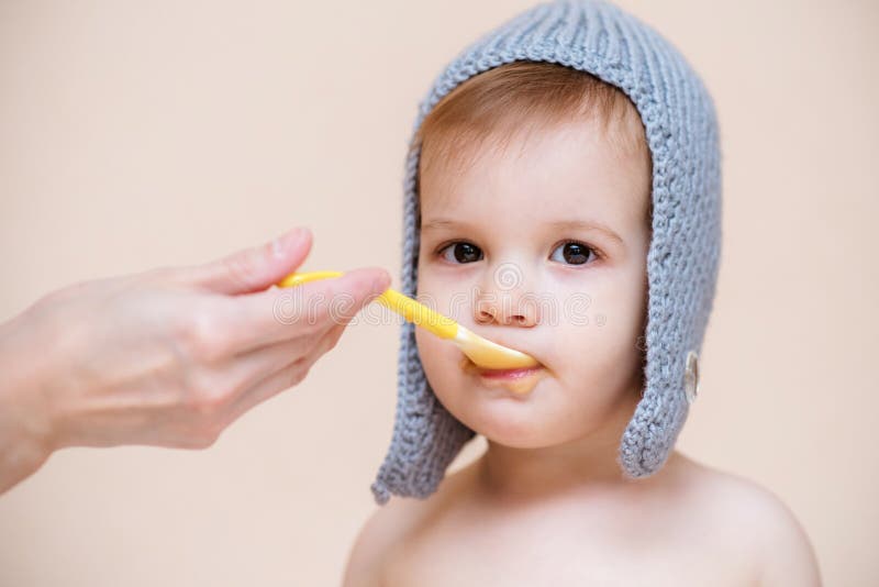 La maman alimente le bébé avec la purée de fruit photographie stock La maman alimente le bébé avec la purée de fruit photographie stock