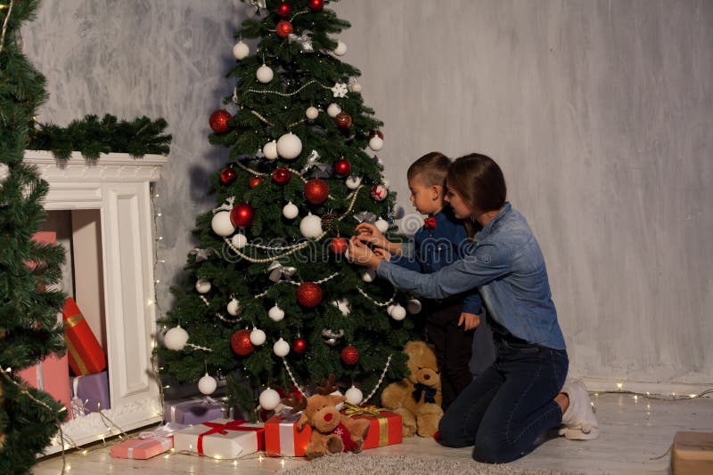 La maman avec le fils orner l'arbre de Noël allume la nouvelle année de Noël images stock La maman avec le fils orner l'arbre de Noël allume la nouvelle année de Noël images stock