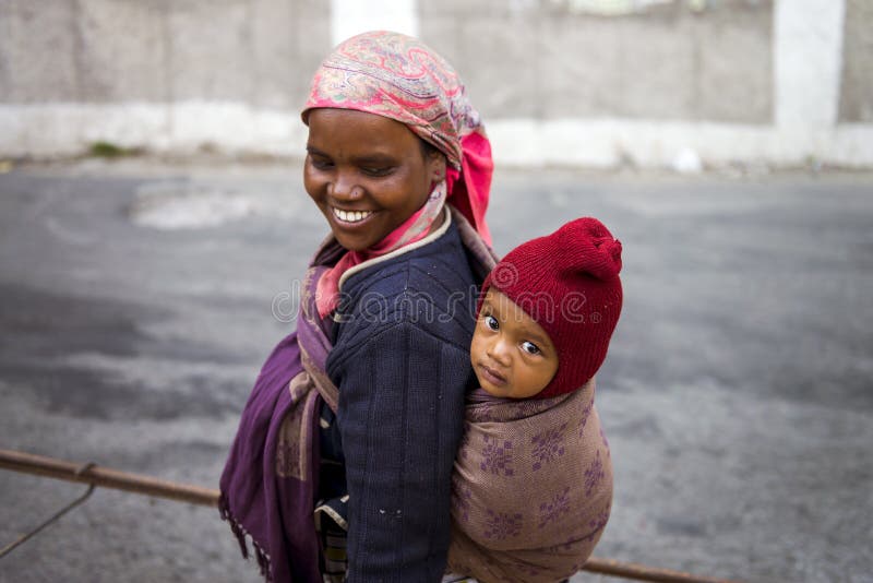 La maman travaillante portent le nourrisson sur son se sentir de retour heureuse pendant sa routine de travail au secteur de Shim photographie stock libre de droits La maman travaillante portent le nourrisson sur son se sentir de retour heureuse pendant sa routine de travail au secteur de Shim photographie stock libre de droits