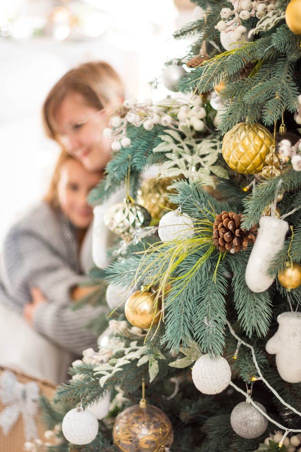 La mamma e la bambina presentano regali di Natale e di Capodanno mentre sono sedute per terra sullo sfondo di un bianco immagine stock libera da diritti La mamma e la bambina presentano regali di Natale e di Capodanno mentre sono sedute per terra sullo sfondo di un bianco immagine stock libera da diritti