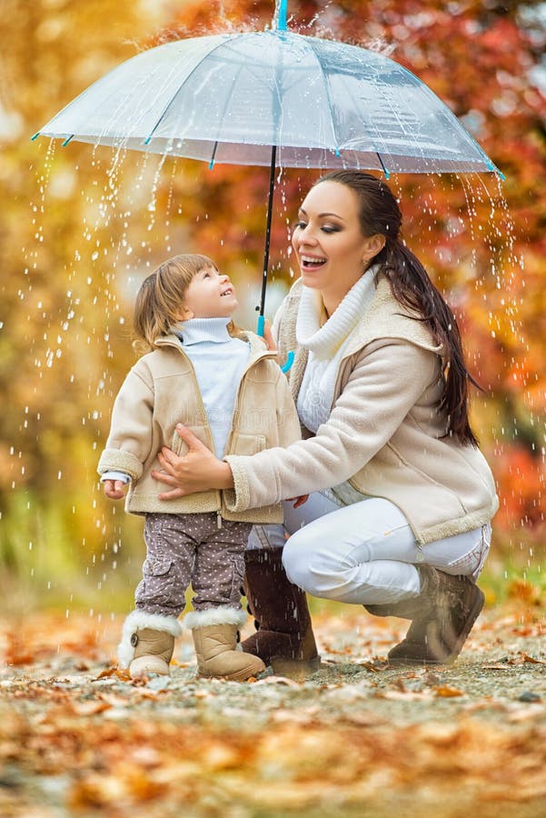La mamma e la figlia sotto l'ombrello si nascondono dalla pioggia