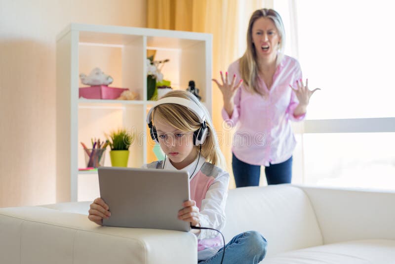 Middle aged mom is angry to her gadgets addicted teenage daughter. Middle aged mom is angry to her gadgets addicted teenage daughter