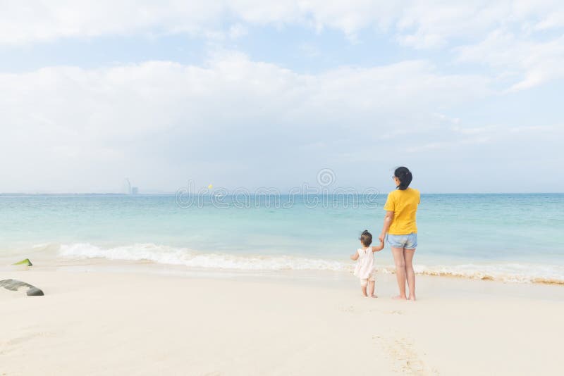 La mamá y poca hija disfrutan del tiempo libre en la playa imágenes de archivo libres de regalías La mamá y poca hija disfrutan del tiempo libre en la playa imágenes de archivo libres de regalías