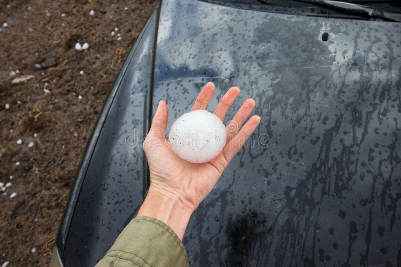 Storm chaser holds a baseball sized hailstone dropped by a supercell thunderstorm. Storm chaser holds a baseball sized hailstone dropped by a supercell thunderstorm.