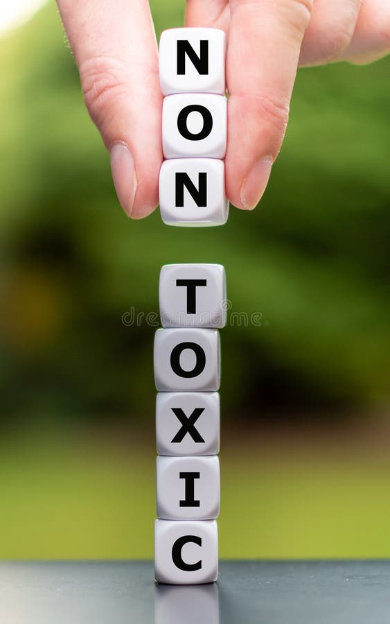 La mano coloca tres dados en una pila y cambia la palabra 'tóxico' a 'no tóxico'